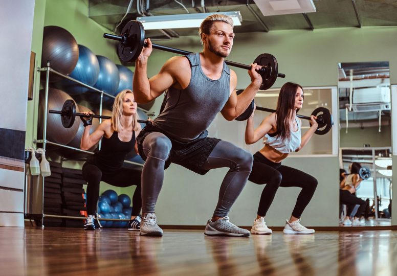 group-of-people-exercising-with-barbell-doing-squa-JUWGZQJ.jpg